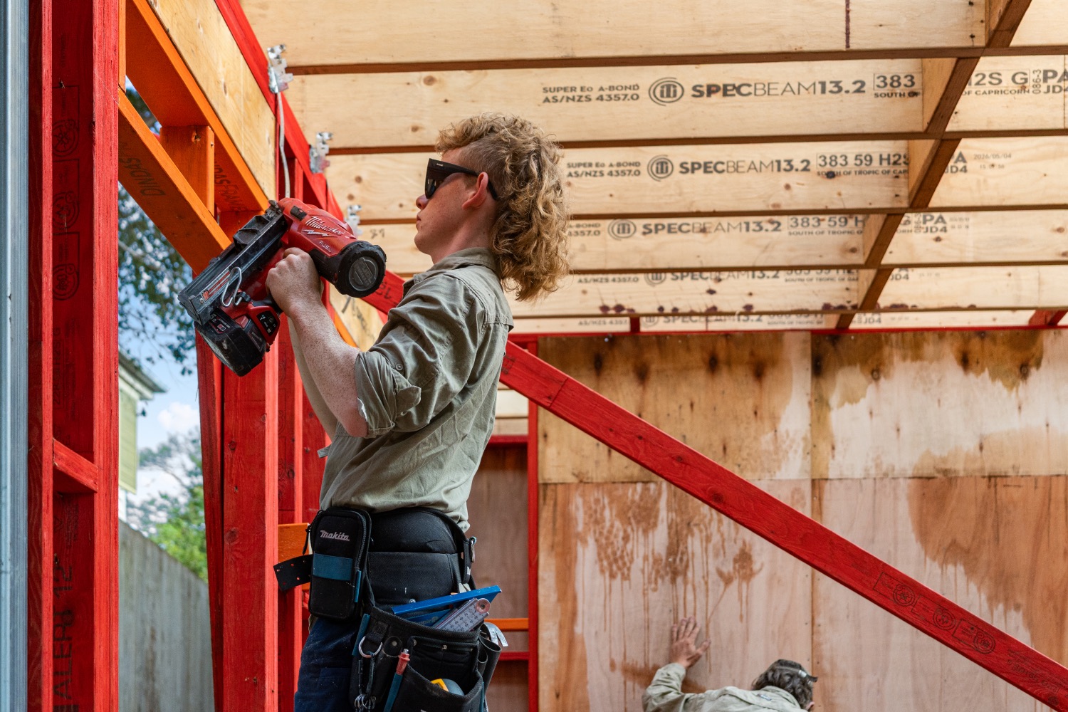 A carpenter fixing new framing with a nail gun