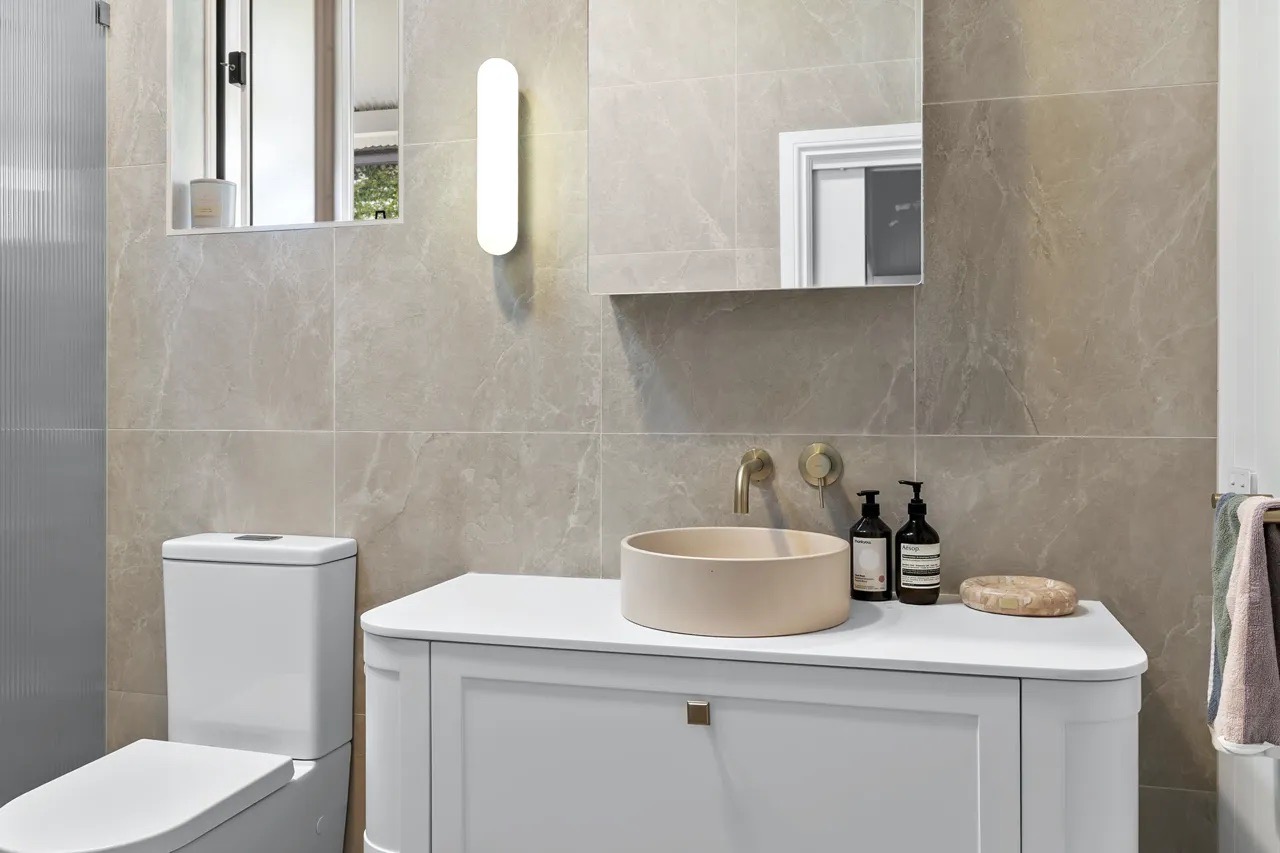 A stone-tiled bathroom with a round basin at Renwick St