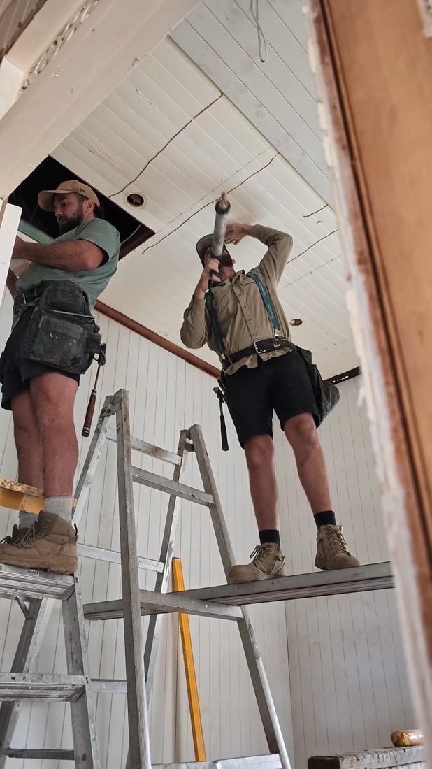 Frame from a clip: a carpenter on a stepladder