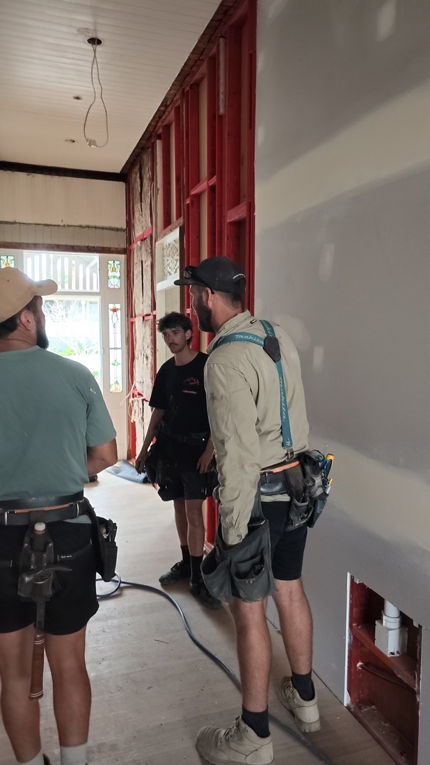 Frame from a clip: two carpenters in a doorway