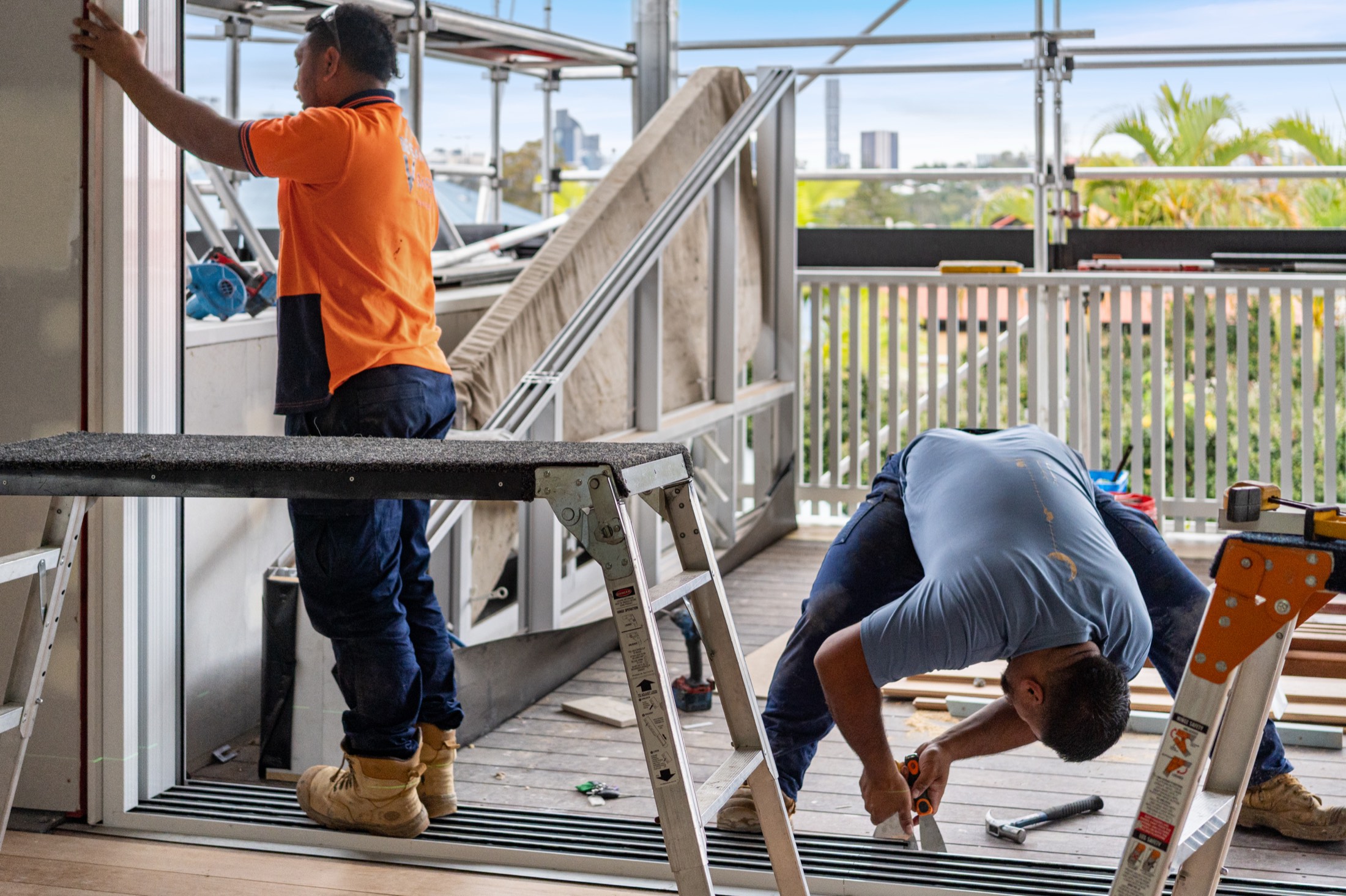 A carpenter cutting at a trestle by the stairs